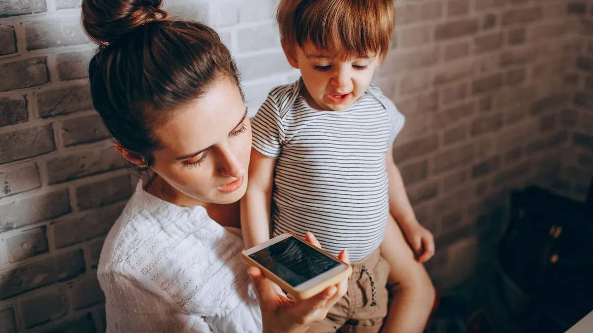 Parent at home checking the benefit deposit date on a phone before choosing a repayment date