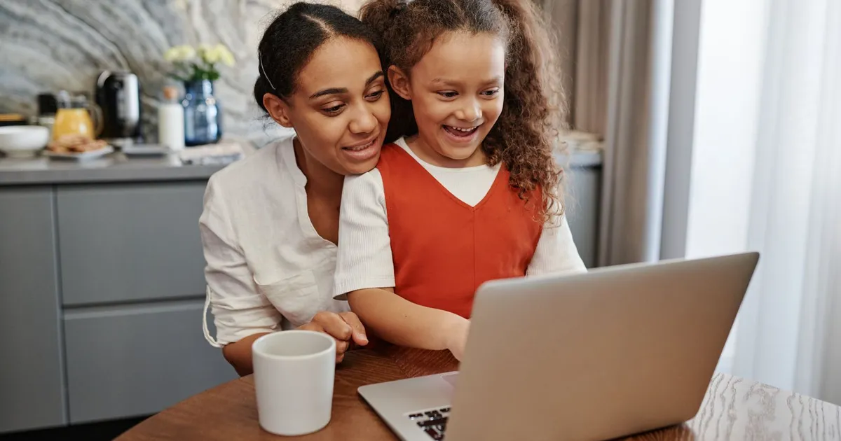 Family at a kitchen table applying on a laptop for a loan on benefits in Canada