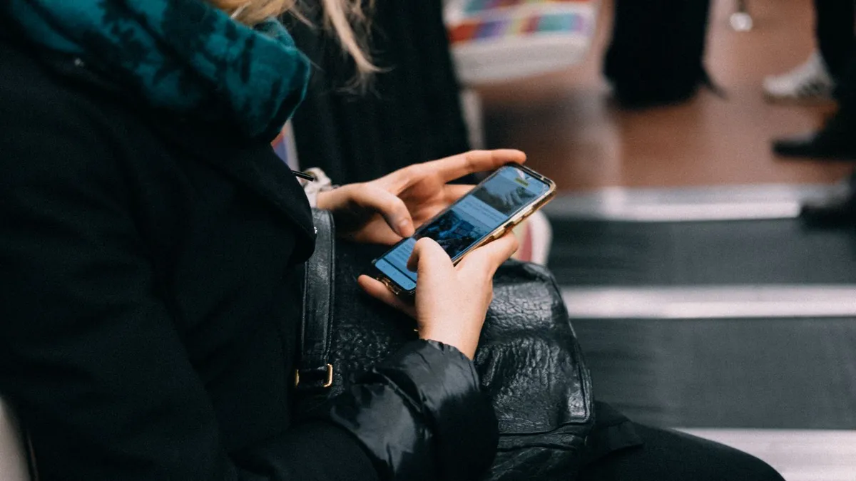 Commuter completing a loan application on a phone during the morning trip to work